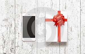Smart phone for Christmas gift on white wooden table with snow