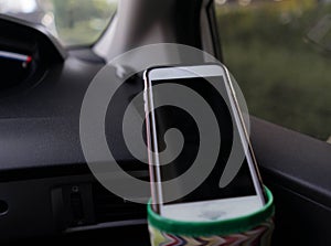 Smart phone hang on cup holder inside car front selective focus