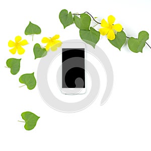 Smart phone with heart shape leaves and yellow flowers