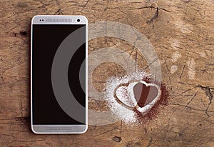 Smart phone and hearts of sugar and cocoa