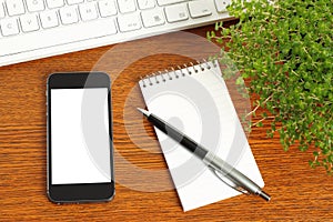 Smart phone, keyboard, notepad, pen and green plant