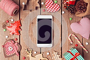 Smart phone mock up with rustic Christmas decorations for app presentation. View from above