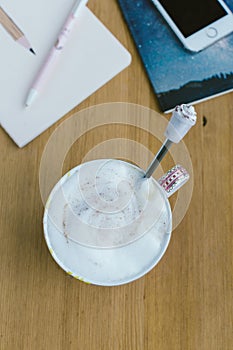 Smart phone with notebook and cup of strong coffee on wooden background.