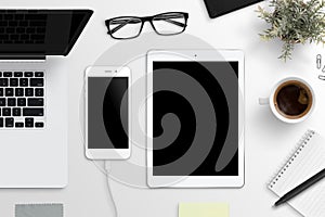 Smart phone and tablet mockup. Office desk with laptop computer, glasses, cup of coffee, notepad and plant