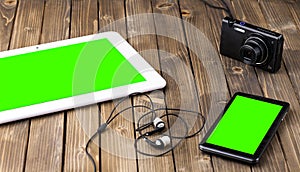 Smart phone, tablet pc and headset on wooden background