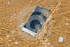 Smart phone with weather on a sandy beach