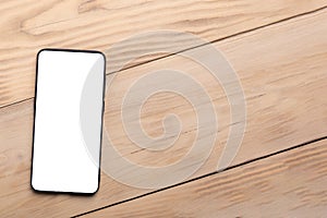 Smart phone on wooden table background with copy space. Flat lay, top view