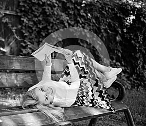 Smart and pretty. Smart lady relaxing. Girl lay bench park relaxing with book, green nature background. Woman spend