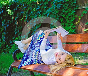 Smart and pretty. Smart lady relaxing. Girl lay bench park relaxing with book, green nature background. Woman spend