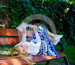 Smart and pretty. Smart lady relaxing. Girl lay bench park relaxing with book, green nature background. Woman spend