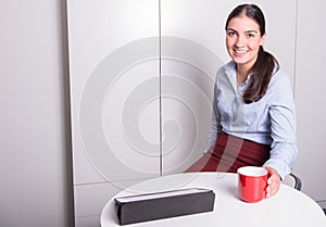 Smart professonal woman is having a coffee break in the office photo