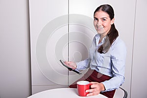 Smart professonal woman is looking on tablet during coffee break photo