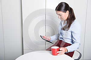 Smart professonal woman is looking on tablet during coffee break photo