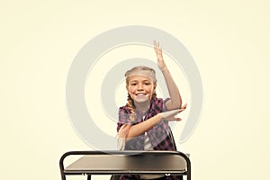 Smart pupil. Primary school pupil. Small pupil raising hand at desk isolated on white. Little pupil reciting lesson in