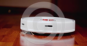 Smart Robot Vacuum Cleaner with lidar on wood floor. Robot vacuum cleaner performs automatic cleaning of the apartment. 4K