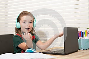 Smart school boy at home writing homework. Little student with notebook computer ready to study. School remote, online