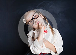 Smart school kid in glasses thinking. Back to school
