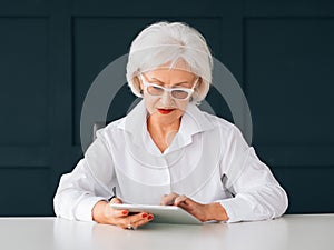 Smart senior woman business intelligence tablet