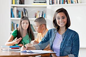 Smart spanish female student with group of learning students