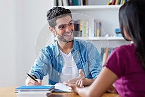 Smart spanish male student preparing for exam on private lesson