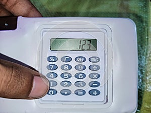 Smart student holding small calculator for solving maths