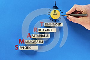 SMART symbol. Concept words SMART specific measurable attainable relevant time-based on block. Beautiful blue background. Business