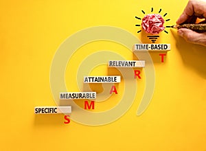 SMART symbol. Concept words SMART specific measurable attainable relevant time-based on block. Beautiful yellow background.