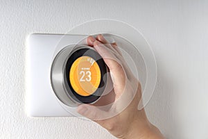 Smart Thermostat with a hand setting up the temperature