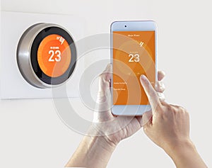 Smart Thermostat and a person setting up the temperature smart device hand hold on a white background