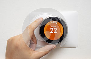 Smart Thermostat with a person warming up the room temperature with a soft shadow