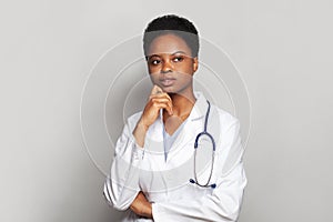 Smart thinking physician woman medical worker with stethoscope standing on white background