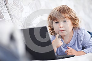 Smart toddler girl using her laptop computer, child and technology