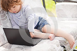 Smart toddler girl using laptop computer, child and technology