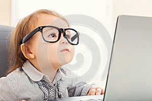 Accorto un bambino logorante il grande occhiali mentre suo computer portatile 