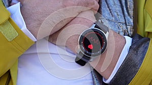 Smart watch measures the pulse on the hand pressed to the heart