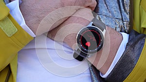 Smart watch measures the pulse on the hand pressed to the heart