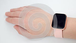 smart watch with a pink strap on a woman& x27;s hand on a white background