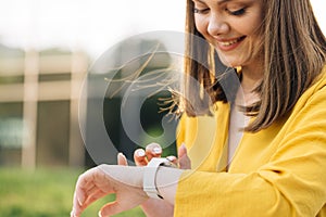 Smart watch. Smart watch on a woman's hand outdoor. Appealing young elegant woman touching a smartwatch. Caucasian photo