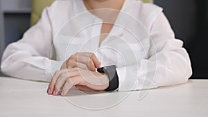 Smart watch on a woman's hand. Female hand touching a smartwatch. Businesswoman hands checking incoming notification on
