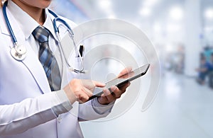 Smart woman doctor holding tablet and pointing to screen