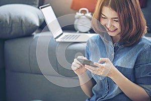 Smart Woman Explore Online Shopping Website on smartphone. Smiling face of asian woman holding cellphone with E-commerce Shopping