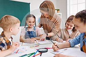 Teacher helping children with schoolwork photo