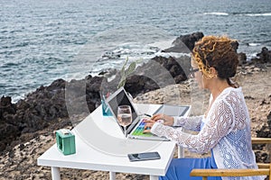 Smart working and digital nomad lifestyle young adult woman using laptop and roaming technology sitting at the desk in outdoor