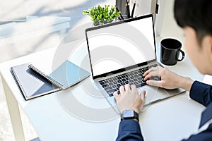 Smart young Asian man using laptop, typing on notebook keyboard, browsing internet