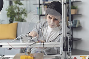 Smart boy using a 3D printer at home