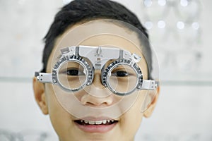 Young boy examining eyesight in optical clinic.