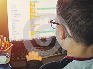 Smart young boy works on a PC for his new project in his computer science class