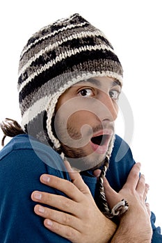 Smart young guy in winter cap shivering from cold