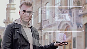 Smart young man with glasses shows a conceptual hologram computer microchip