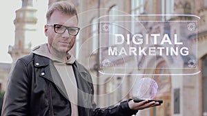 Smart young man with glasses shows a conceptual hologram Digital marketing